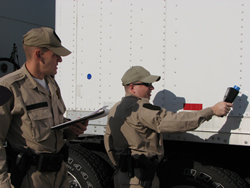Two officers checking a truck for nuclear material