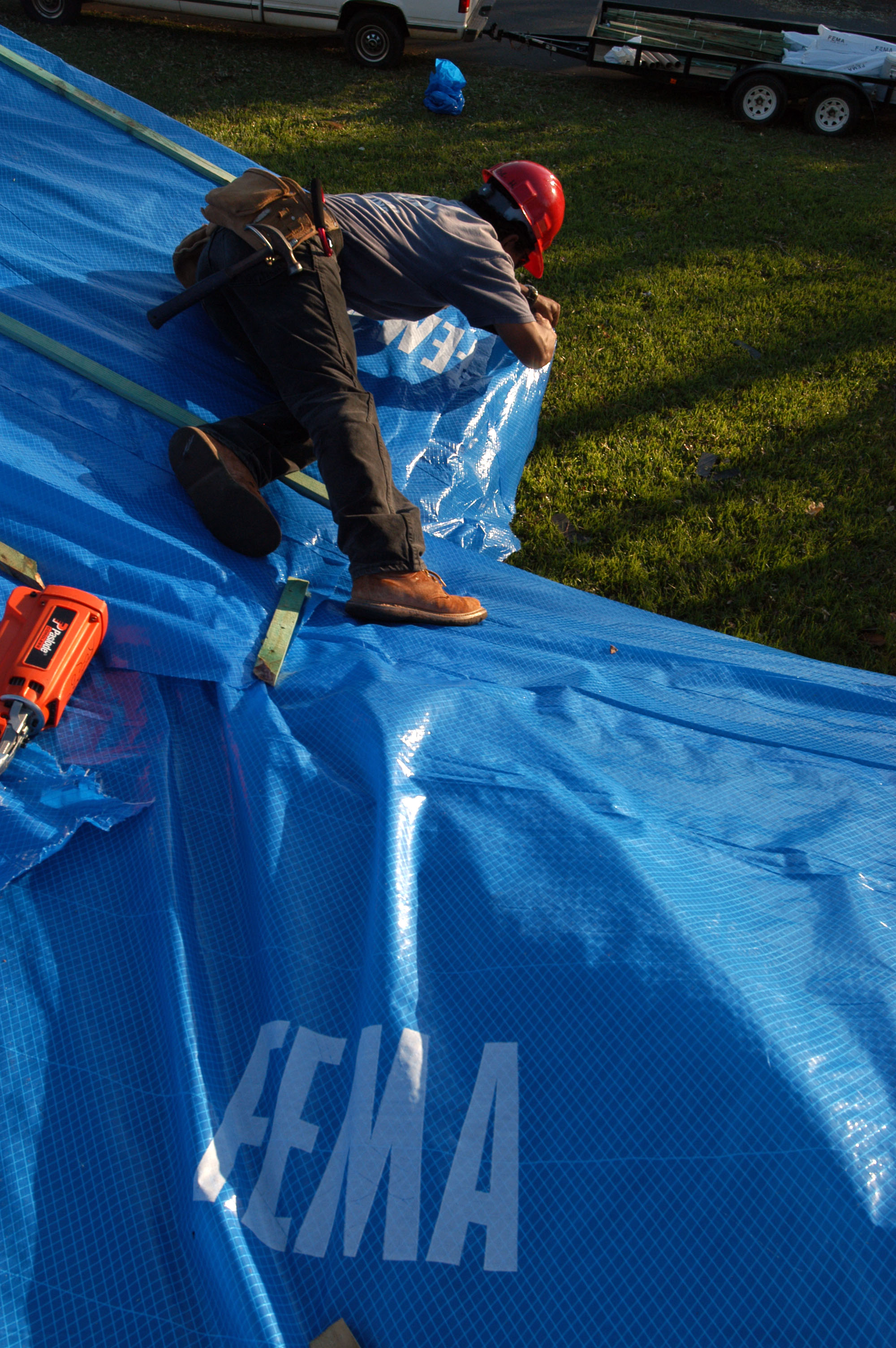 Operation Blue Roof A contractor puts a tarp provided by FEMA on a