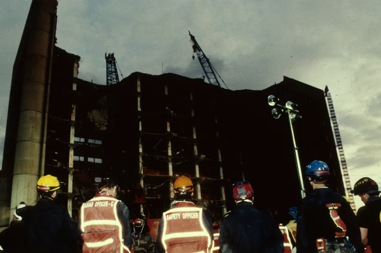 Image: Oklahoma City Bombing - Search and Rescue workers gather outside at night