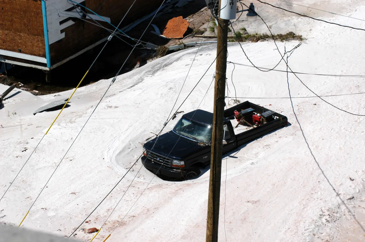 Image: Hurricane Ivan - A car stranded and covered in sand and debris