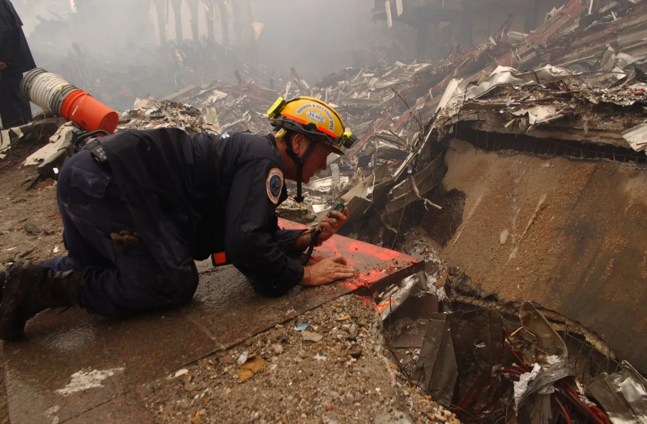 Image: 9/11 - A rescue worker talks to a co-worker inside the pile of rubble at Ground Zero