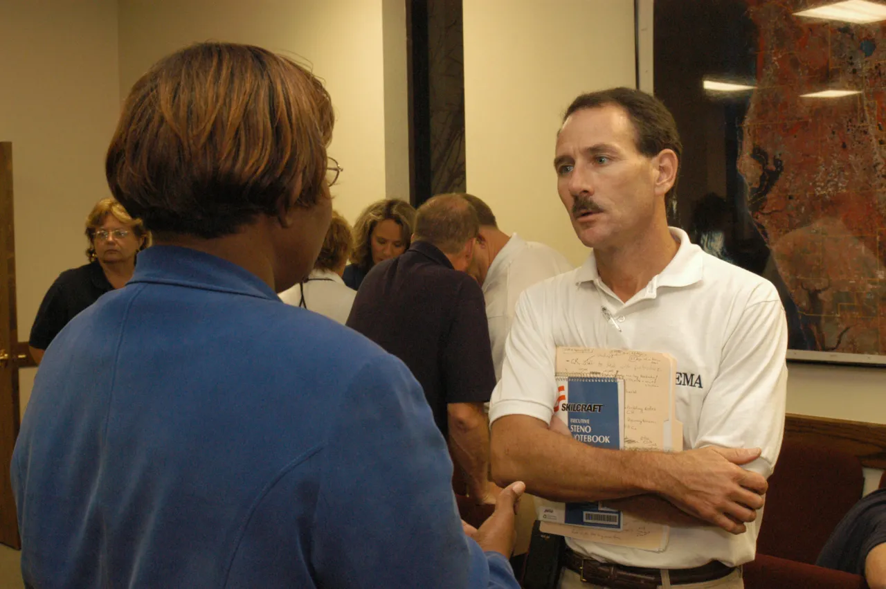 Image: Hurricane Charley - A FEMA employee listens to a concerned citizen