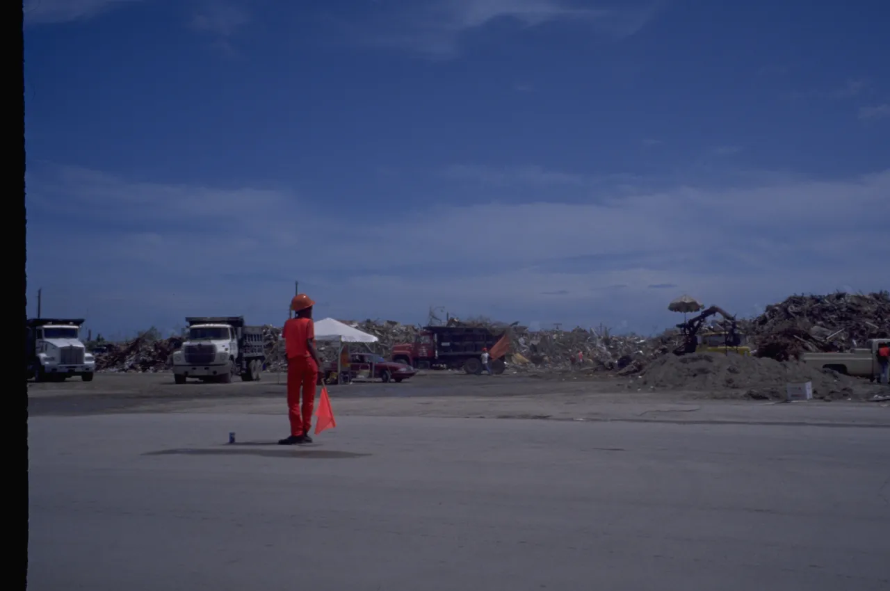 Image: Hurricane Andrew - A worker stands ready to direct vehicles for cleanup