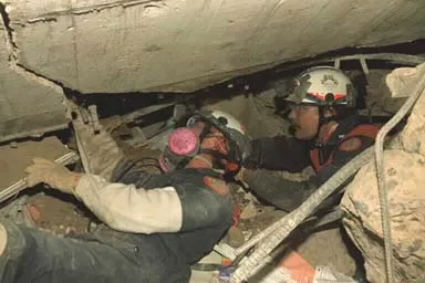 Image: Oklahoma City Bombing - Task Force members maneuver through a crawl space