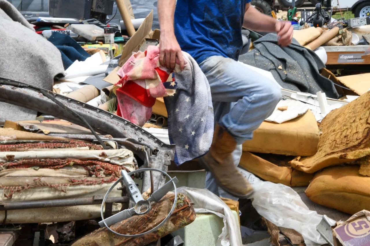 Image: Volunteer Walks Over Rubble in Tornado Aftermath