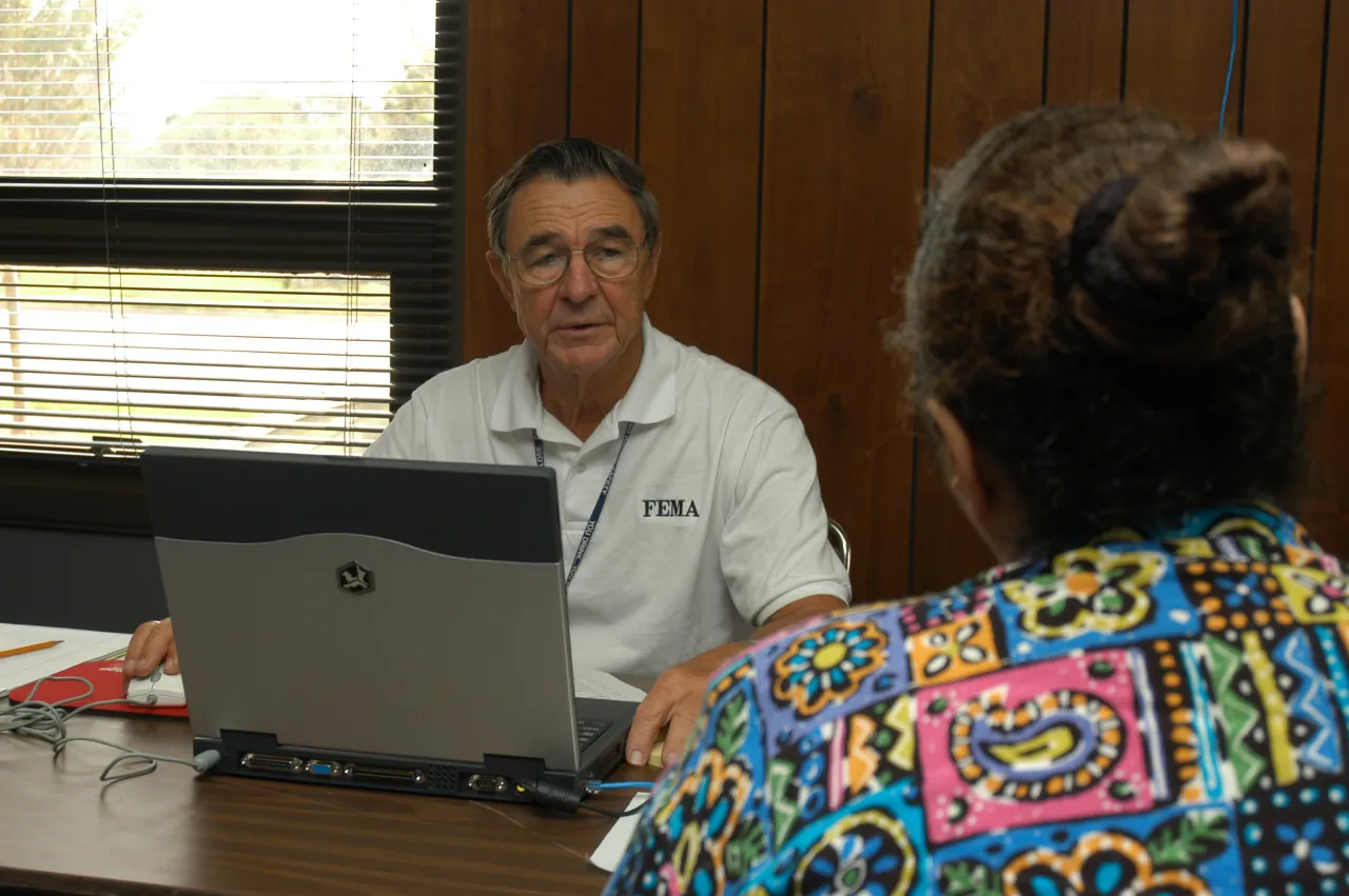 Image: Hurricane Charley - A FEMA employee assists a resident affected by Charley