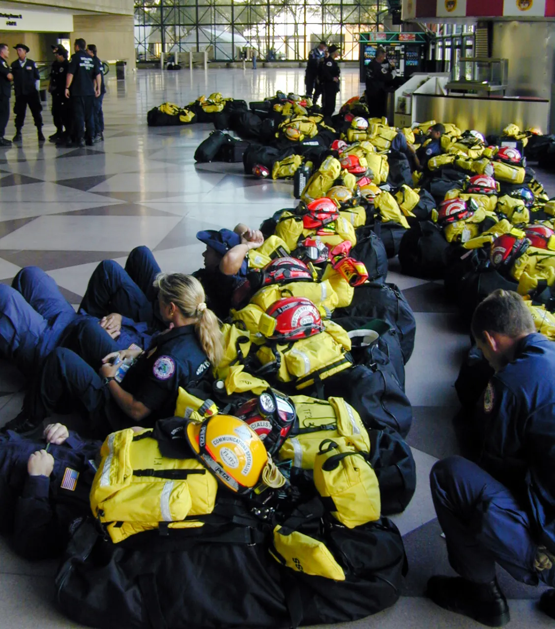 Image: 9/11 - Firefighter and rescue teams, surrounded by their supplies, wait to be dispatched to the World Trade Center disaster site