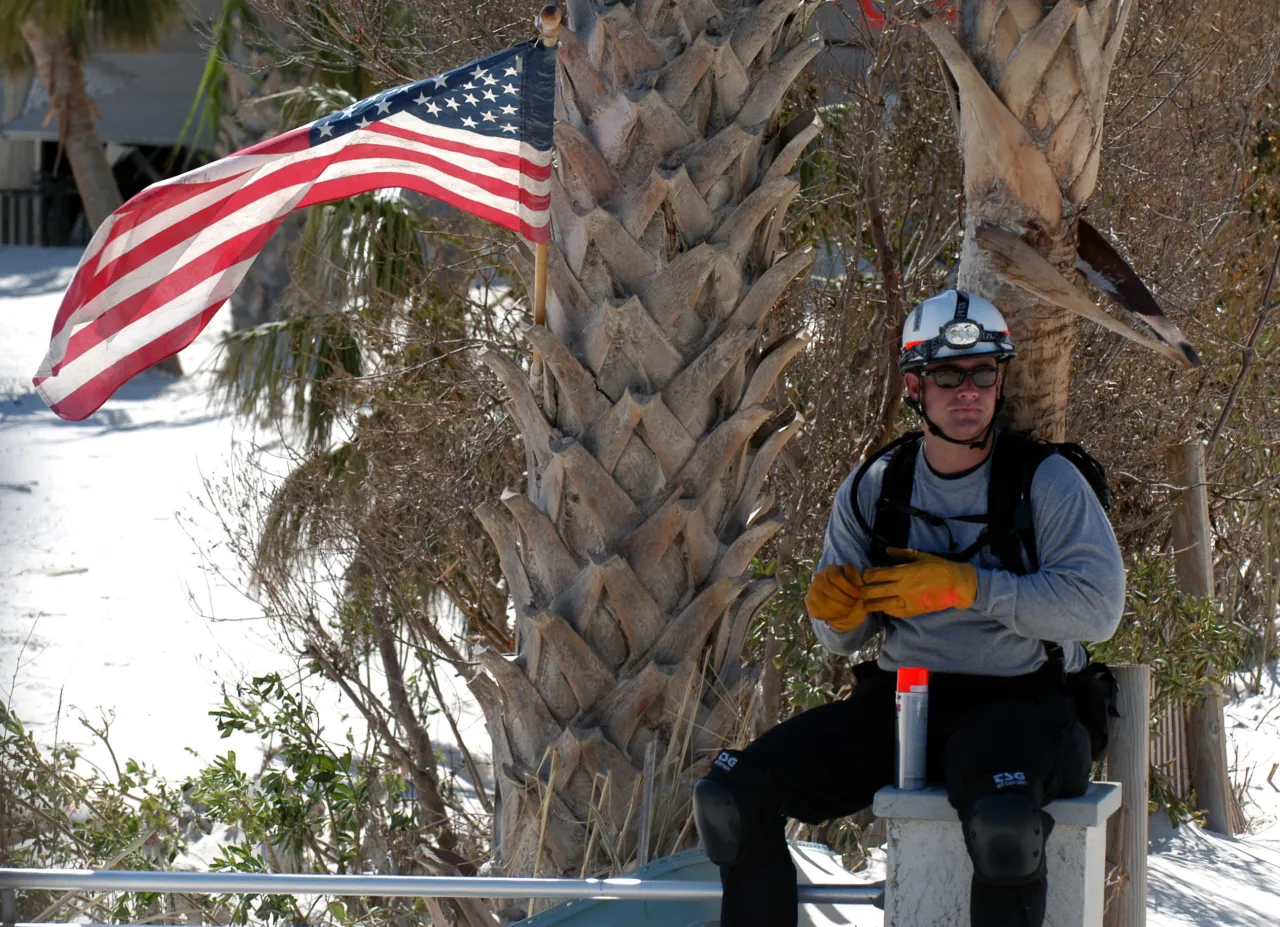 Image: Hurricane Ivan - A rescue worker takes a break and surveys the area for trapped survivors.