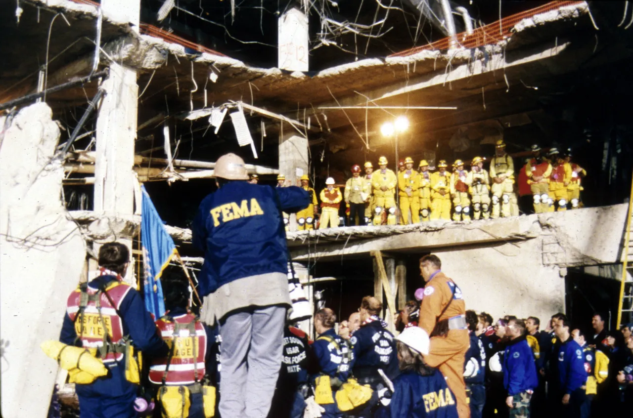 Image: Oklahoma City Bombing - Search and Rescue workers meet at the scene