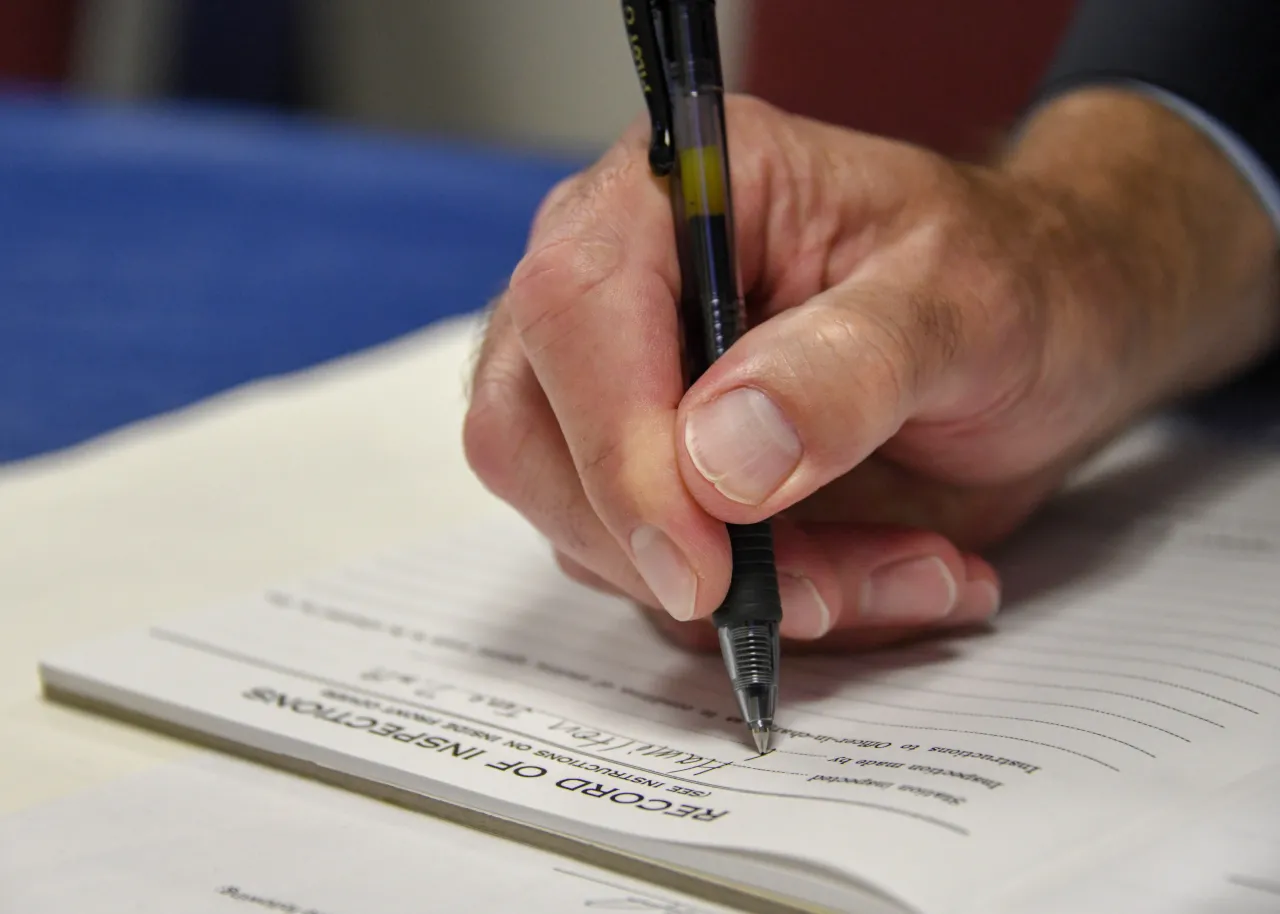 Image: U.S. Coast Guard (USCG) Officer signing a piece of paper