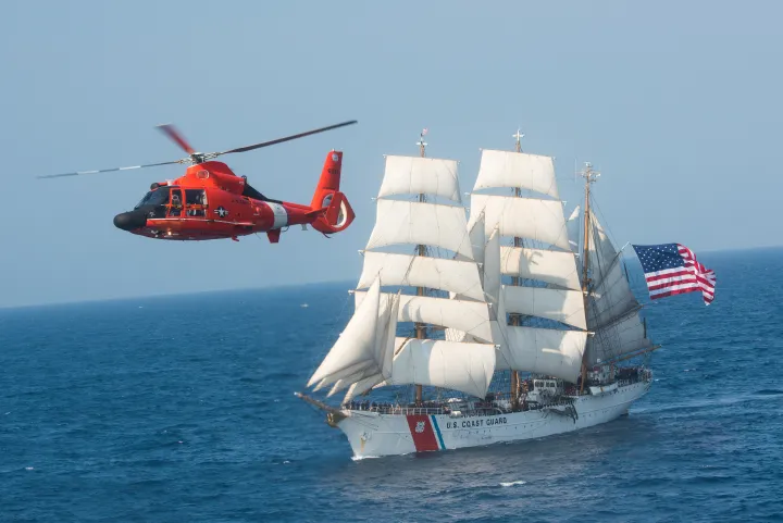 Image: US Coast Guard Barque Eagle and MH-65 Helicopter