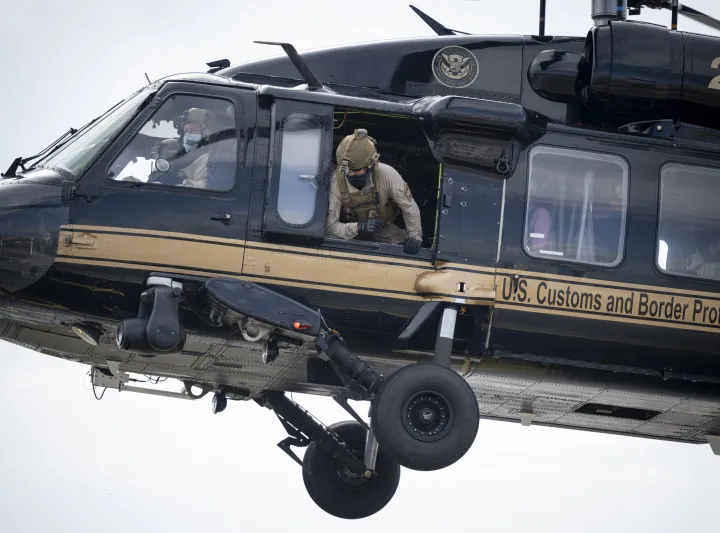 Image: U.S. Customs and Border Protection (CBP) Officer Leaning Out of a CBP Helicopter
