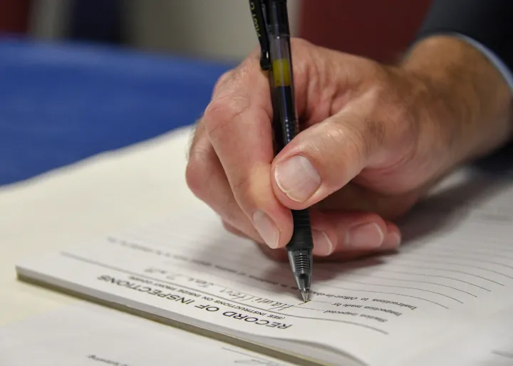 Image: U.S. Coast Guard (USCG) Officer signing a piece of paper