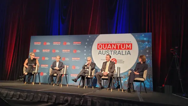 Under Secretary Kusnezov sitting on a stage with four other people speaking on a panel at the Quantum Australia Conference in Sydney.