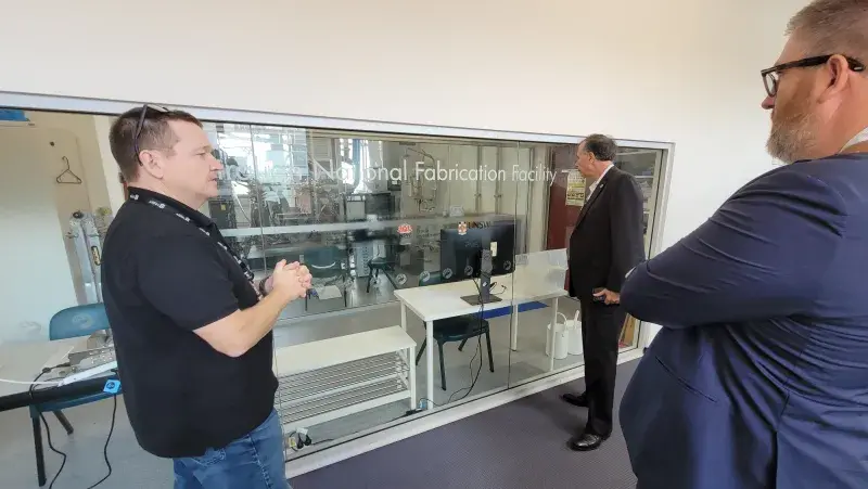 Under Secretary Kusnezov in a room with two other people touring the Australian National Fabrication Facility during his visit to the University of New South Wales.