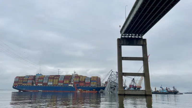 View of the container ship and collapsed bridge from under the remaining bridge.