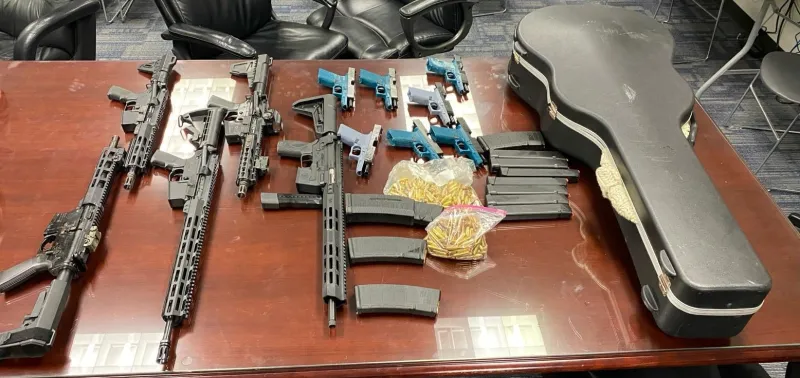 Ghost guns, assault rifles, high-capacity magazines, ammunition, and a guitar case where guns were hidden recovered from an Elmhurst garage defendants used to store weapons.