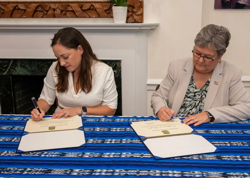 Deputy Chief of Mission Viviana Arenas and HSI EAD Katrina W. Berger signing during the repatriation ceremony to return significant cultural artifacts to the people of Guatemala.