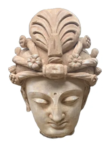The fragmentary stone head of Buddha has been finely modeled with a meditative expression and wears an elaborate headdress with central lotus flower.