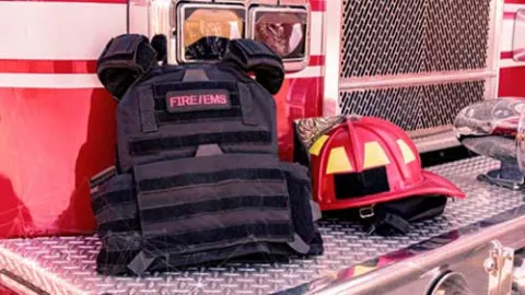 Fire fighter vest and helmet on front of fire truck 