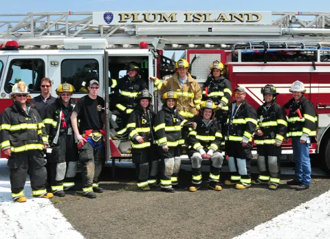 A group of Plum Island firefighters standing in front of a fire truck.