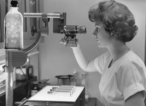 A woman in the PIADC lab using equipment examining plaque assays.