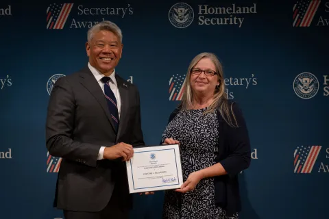 DHS Deputy Secretary John Tien with Team Excellence Award recipient, Christine L. McClenning.