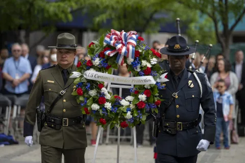 Two CBP Officers carry wreath where Homeland Security Secretary Alejandro Mayorkas and Deputy Secretary John Tien attend the 2022 CBP Honor Memorial event at the Woodrow Wilson Plaza.
