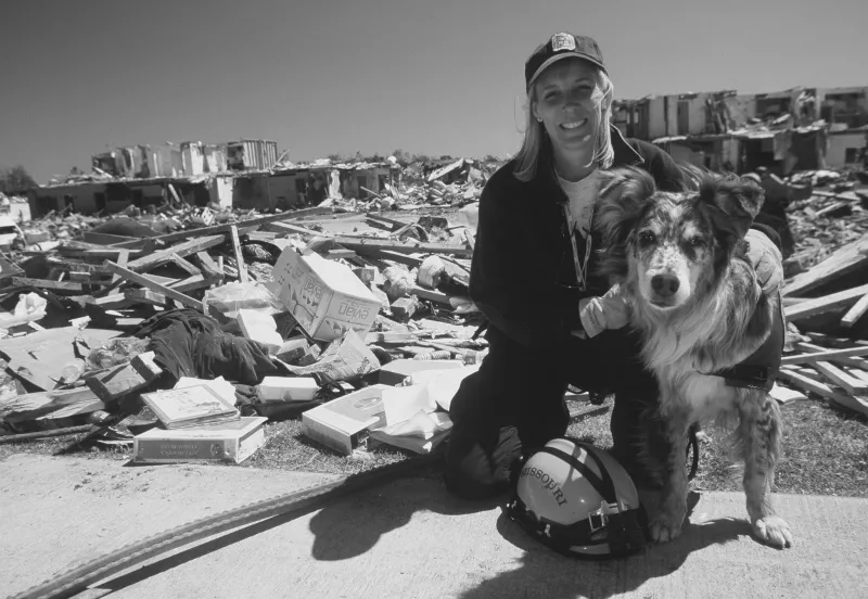 FEMA employee and FEMA dog on disaster site.