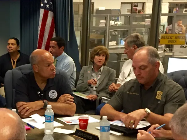 Secretary Johnson sits next to Governor John Bel Edwards during emergency operations briefing