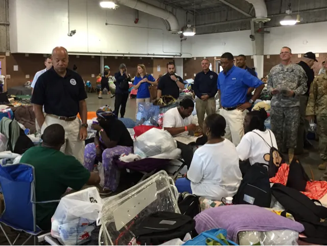 Secretary Johnson talks with displaced resident surrounded by personal belongings