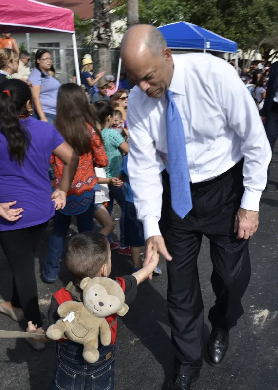 During the International Bridge Ceremony parade, Secretary Johnson greets a small child.