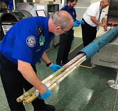 A TSA officer at Tyson Airport (TYS) inspecting pole-vaults, which can be transported in checked baggage. Photo courtesy of TSA.