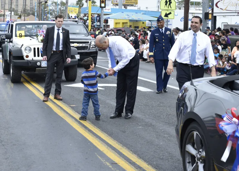 During the International Bridge Ceremony parade, a child runs up to greet Secretary Jeh Johnson.