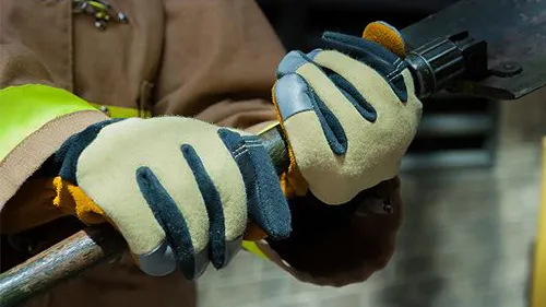 First responder hands with a protective glove holding a metal piece of equipment.