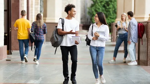 Photo of a man and a woman talking and walking on the street