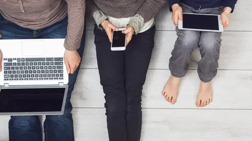 3 people using a laptop, smartphone, and tablet respectively.