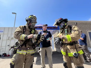 Two firefighters gearing up during an operational field assessment at the San Diego Fire-Rescue Training Facility.