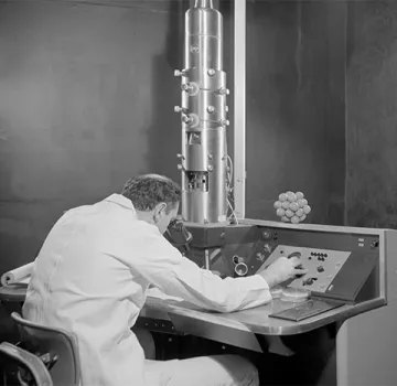 Dr. Syndey S. Breese Jr. uses an electron microscope while working in a PIADC laboratory.