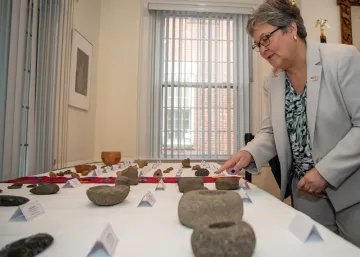 Photo of HSI EAD Katrina W. Berger examining 54 Mesoamerican artifacts during the repatriation ceremony.