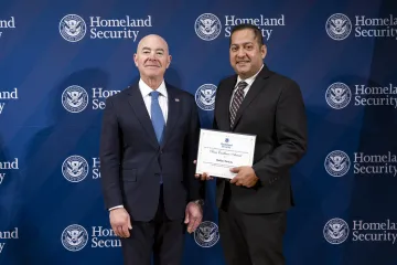 DHS Secretary Alejandro Mayorkas with Team Excellence Award recipient, Baibhav Devkota.