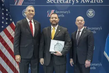 FLETC Director Benjamine Huffman (left), Innovation Award recipient Christopher L. Sanders (center), with DHS Secretary Alejandro Mayorkas (right).