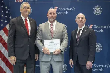 FLETC Director Benjamine Huffman (left), Innovation Award recipient Jimmy N. Palmer (center), with DHS Secretary Alejandro Mayorkas (right).