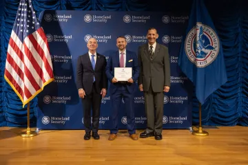 DHS Secretary Alejandro Mayorkas (left) with Team Excellence Award recipient, Mark Denis (center), and Deputy Under Secretary for Management, Randolph Alles (right).