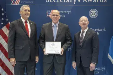 FLETC Director Benjamine Huffman (left), Innovation Award recipient Carl M. Willis (center), with DHS Secretary Alejandro Mayorkas (right).