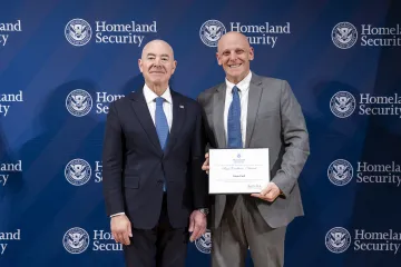 DHS Secretary Alejandro Mayorkas with Team Excellence Award recipient, Gabriel Soll.
