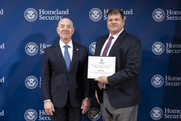 DHS Secretary Alejandro Mayorkas with Team Excellence Award recipient, Keith Puzder.