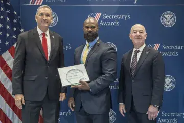 FLETC Director Benjamine Huffman (left), Innovation Award recipient Corey E. Henderson (center), with DHS Secretary Alejandro Mayorkas (right).